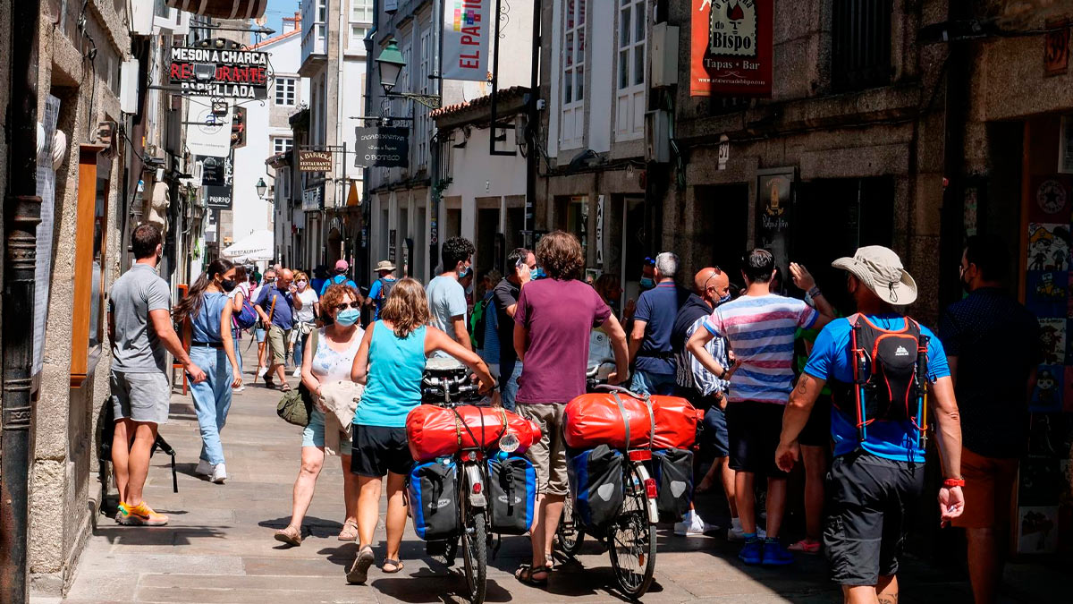 Varios peregrinos caminan por las calles de Santiago