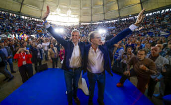 El líder del PP, Alberto Núñez Feijóo (d), y el presidente de la Xunta y candidato a la reelección, Alfonso Rueda (i), saludan al comienzo del mitin que ofrecen los populares este sábado en la plaza de toros de Pontevedra. EFE/Lavandeira Jr