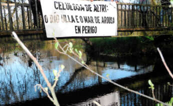 Pancarta en contra de Altri en un puente sonbre el río Ulla a su paso por Monterroso