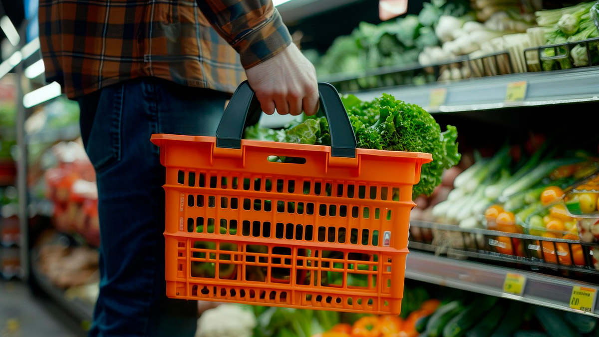 Persona con una cesta naranja comprando en un supermercado
