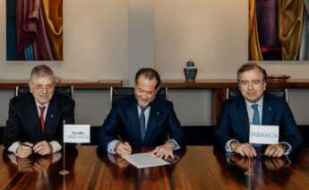 Juan Carlos Escotet (centro) y Francisco Botas (derecha), presidente y consejero delegado de Abanca en la firma, en julio del año pasado, de la adquisición de la financiera lusa Eurobic