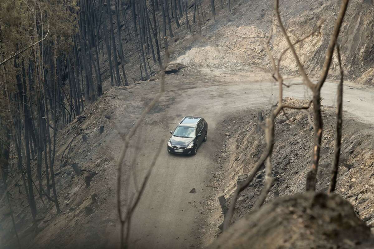 Un coche circula al lado del terreno calcinado en A Barca, Sober / Europa Press