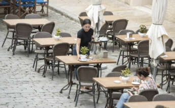 MAHÓN (MENORCA), 23/05/2022.- Una trabajadora recoge una mesa este lunes en la ciudad balear de Mahón. Según la empresa de recursos humanos Randstad, Baleares es la zona con más ofertas en la hostelería. EFE/ David Arquimbau Sintes