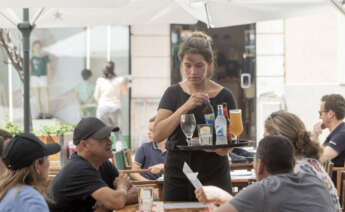 GRAF6149. MAHÓN (MENORCA), 19/05/2022.- Una camarera trabaja en un bar de la ciudad de Mahón este jueves. El empleo en el sector turístico en Baleares creció el pasado abril un 125,5 % en comparación al mismo mes de 2021, que supone el mayor incremento interanual en el país, seguida de Andalucía, con un ascenso del 33,6 %, según las cifras publicadas por Turespaña. EFE/David Arquimbau Sintes