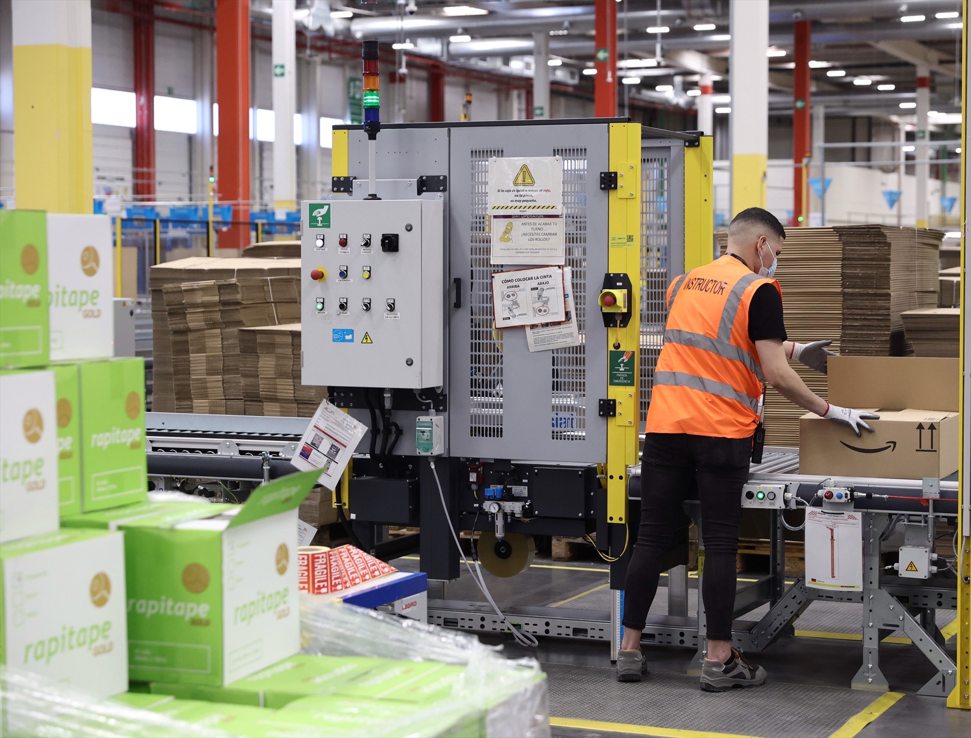 Un trabajador prepara un pedido, en una caja de cartón, en las instalaciones del Centro Logístico de Amazon.