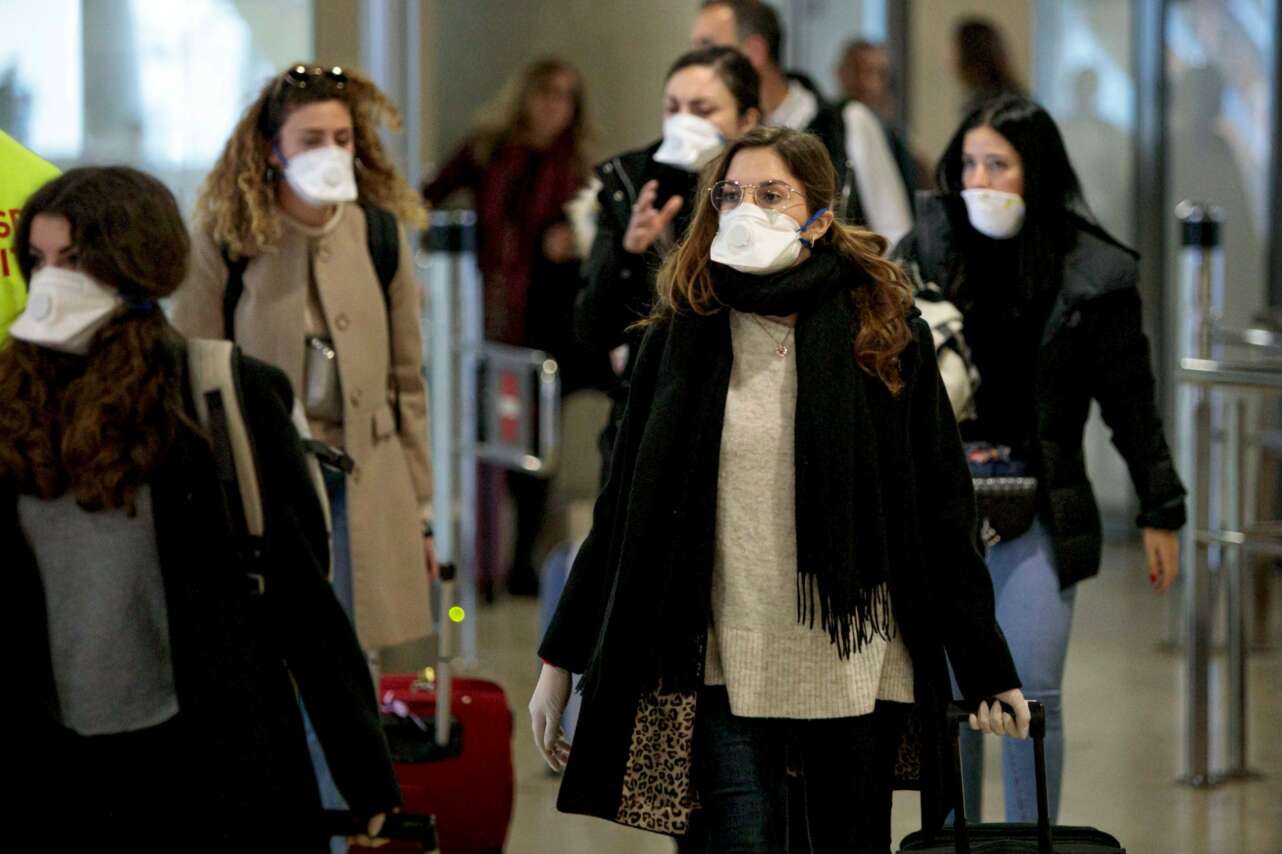 Viajeros protegidos con mascarillas por el coronavirus